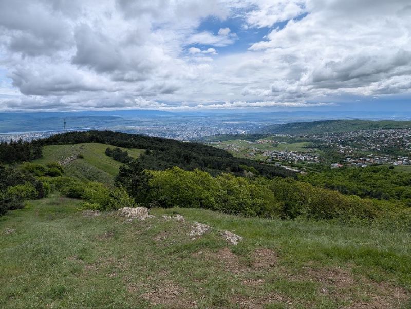 Green ridges with Tbilisi in the distance.